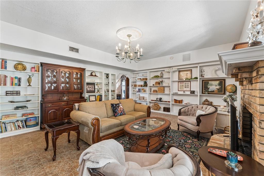 A living room features built-in white bookshelves, a brick fireplace, and a central chandelier — 9130 DOLLANGER COURT, ORLANDO, FL
