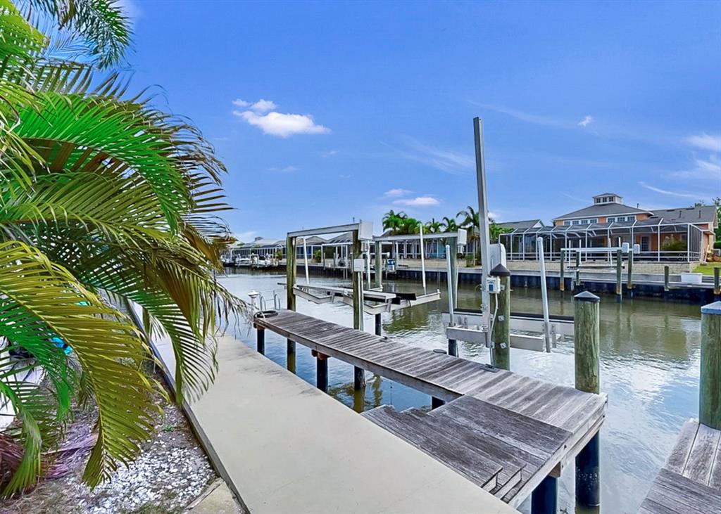 A single-story orange house with a front porch, garage, and palm trees in the yard — 5715 SEA TROUT PLACE, APOLLO BEACH, FL