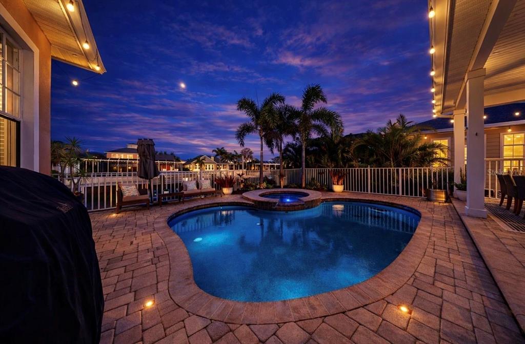 A single-story house with a front porch, palm trees, and exterior lighting at dusk — 5715 SEA TROUT PLACE, APOLLO BEACH, FL