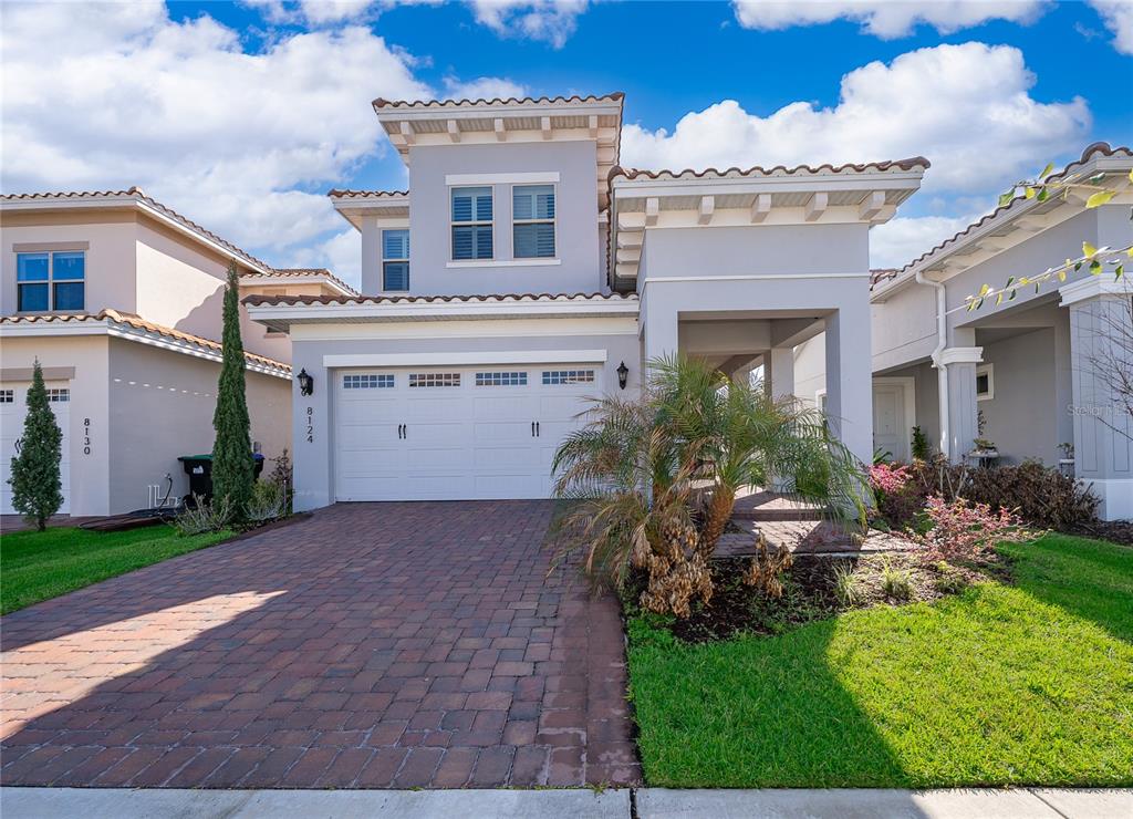 A two-story house with a paved driveway, a two-car garage, and a covered entryway — 8124 MABURY LANE, ORLANDO, FL