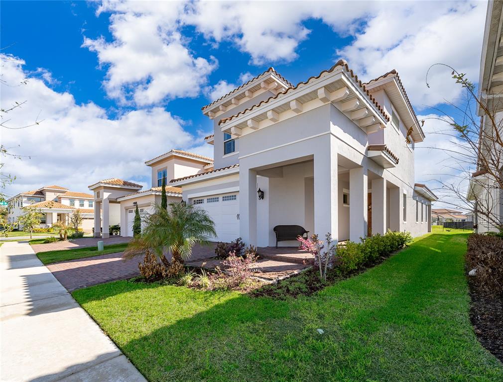 A two-story suburban house with a light gray exterior, a tiled roof, and a paved driveway — 8124 MABURY LANE, ORLANDO, FL