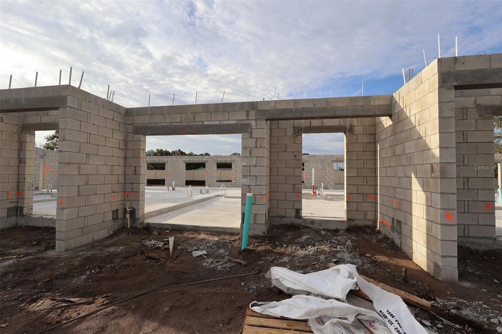 An exterior view of a residential construction site featuring concrete block walls and a concrete slab — 6067 FELLOW WAGON WAY, ORLANDO, FL