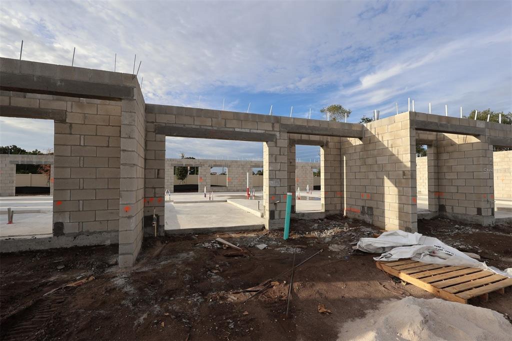 Construction site showing the concrete block walls and foundation of a house under development — 6067 FELLOW WAGON WAY, ORLANDO, FL