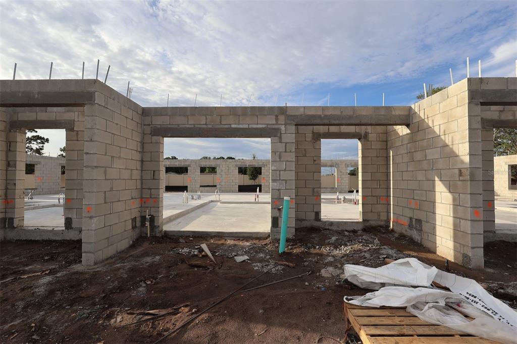 An exterior view of a residential construction site showing concrete block walls and open doorways — 6067 FELLOW WAGON WAY, ORLANDO, FL