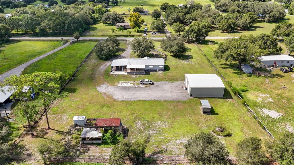 An aerial view shows a house, a detached garage, and several outbuildings on a rural lot — 4480 FORT SIMMONS AVENUE, LABELLE, FL