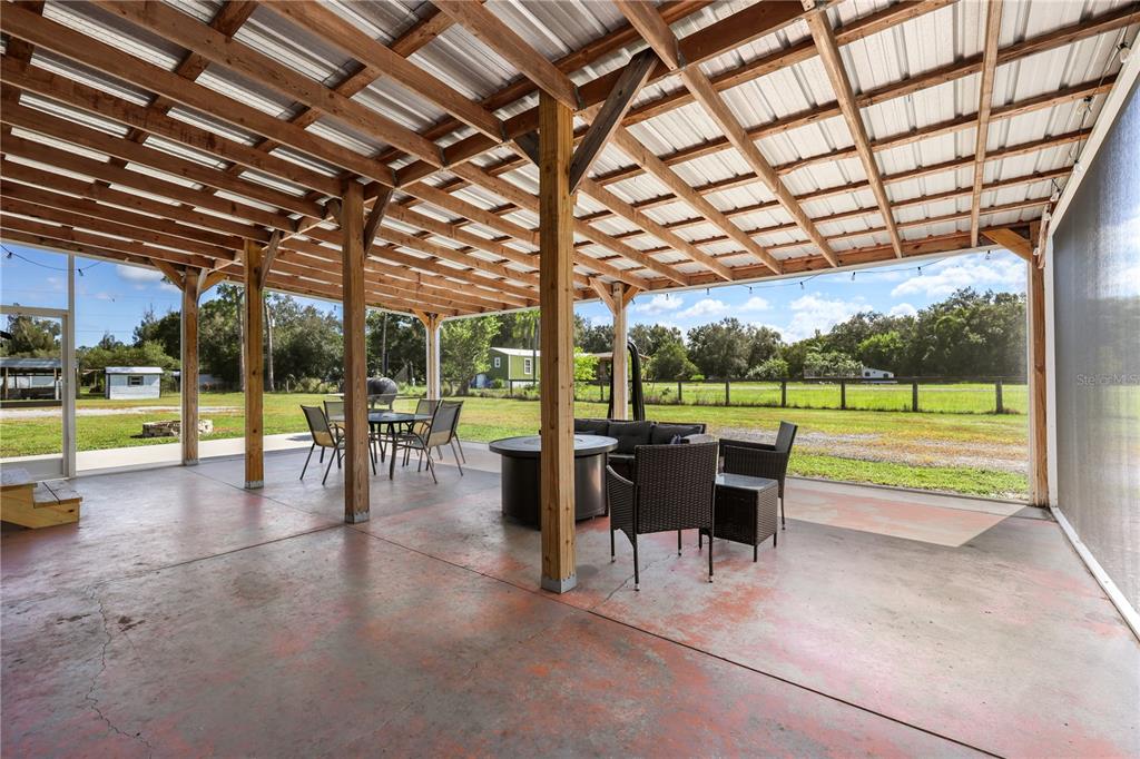 A covered outdoor patio features a concrete floor, wooden support beams, and patio furniture — 4480 FORT SIMMONS AVENUE, LABELLE, FL