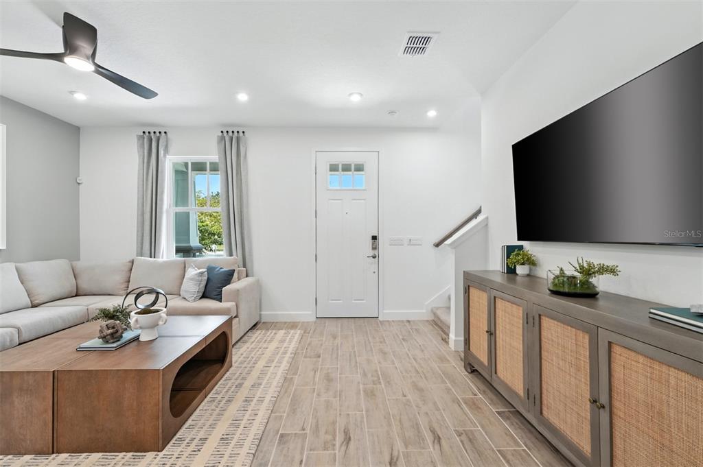 A living room features a sectional sofa, a wooden coffee table, and a media console — 1792 HEADLAND LOOP, CELEBRATION, FL