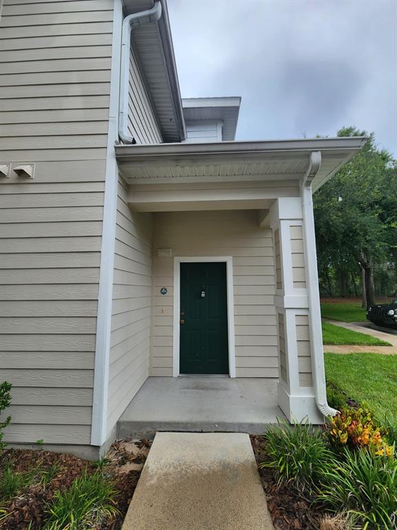 A staircase with wood-look treads and white risers leads upward between two plain walls — 142 SOUTHERN PECAN CIRCLE UNIT 204, WINTER GARDEN, FL