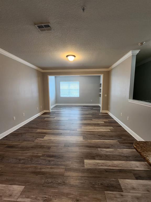 A kitchen features white cabinets, granite countertops, tile flooring, and white appliances — 142 SOUTHERN PECAN CIRCLE UNIT 204, WINTER GARDEN, FL