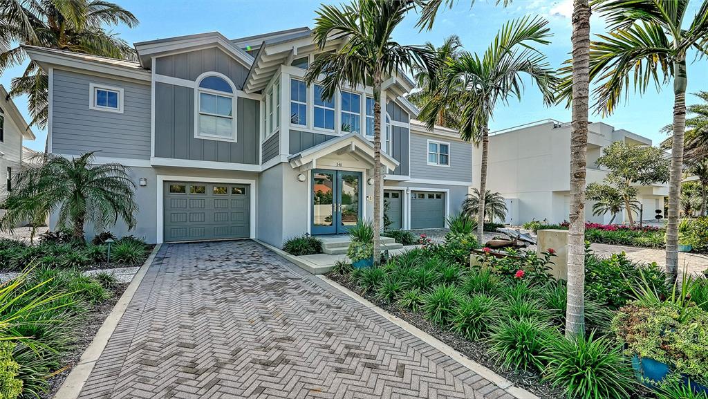A two-story house with gray siding, a brick driveway, and palm trees in the front yard — 340 MORNINGSIDE DRIVE, SARASOTA, FL