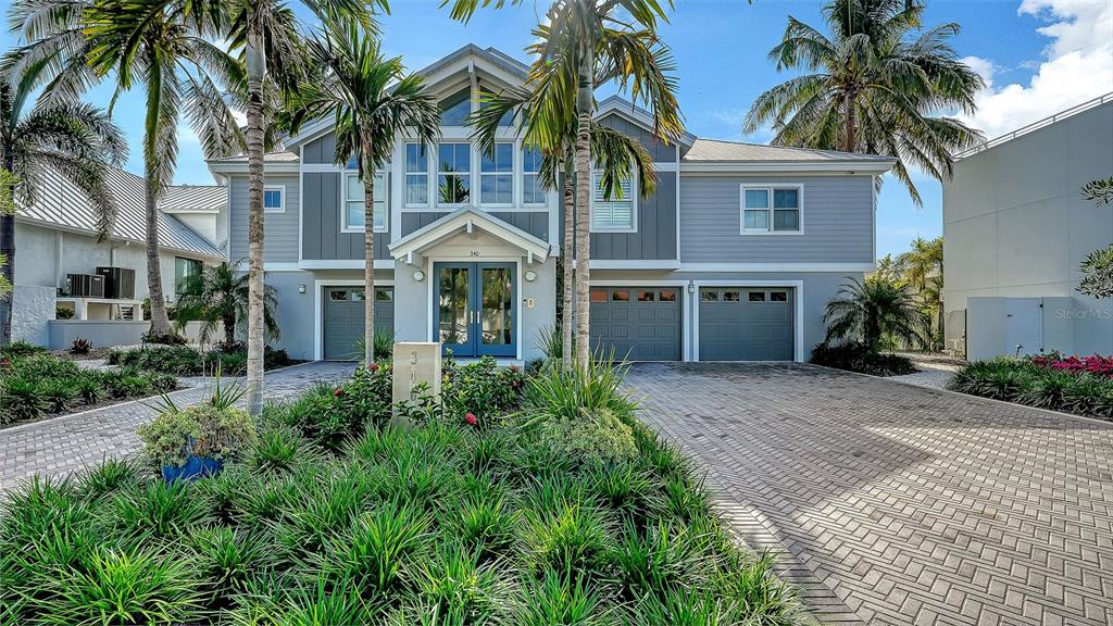 A two-story house with gray siding, a paved driveway, and palm trees in the front yard — 340 MORNINGSIDE DRIVE, SARASOTA, FL