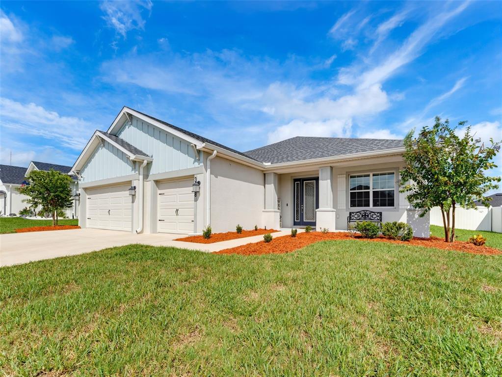 A single-story house with a two-car garage, light-colored stucco siding, and a front lawn — 3158 KENDAL WAY, LAKELAND, FL