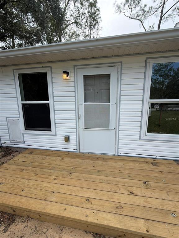 A wooden deck sits in front of a white-sided house with a door and two windows — 9314 SW 32ND TERRACE, OCALA, FL