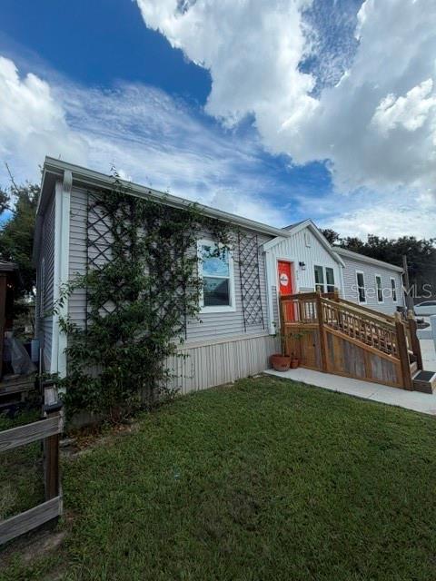 A light gray manufactured home sits next to a detached two-car garage with concrete driveway — 950 LAKE COVE TRAIL, LAKELAND, FL