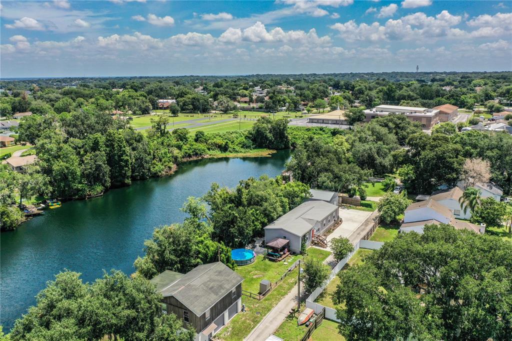 A light gray manufactured home features a wooden gazebo on a deck and a staircase entrance — 950 LAKE COVE TRAIL, LAKELAND, FL