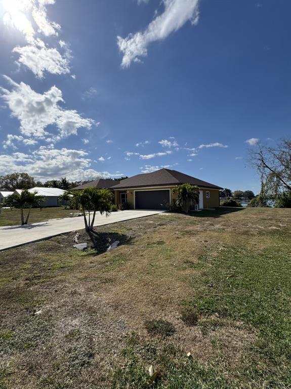 A single-story house with a two-car garage sits on a large, grassy lot — 2809 SE 27TH AVENUE, OKEECHOBEE, FL