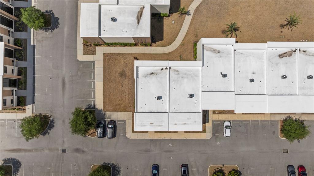 An aerial view shows a commercial building complex with flat roofs and surrounding parking lots — 7526 BROOKLYN DRIVE, KISSIMMEE, FL