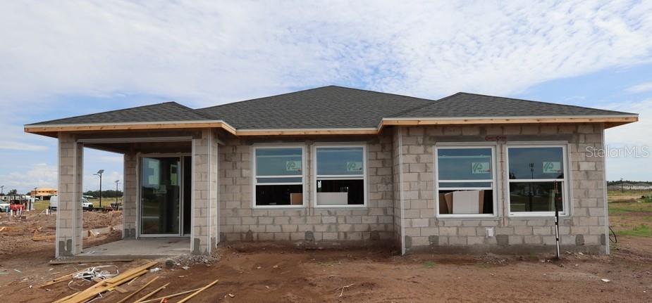 The exterior of a single-story house under construction features concrete block walls and a shingled roof — 5141 CHATTAHOOCHEE BEND, ST CLOUD, FL