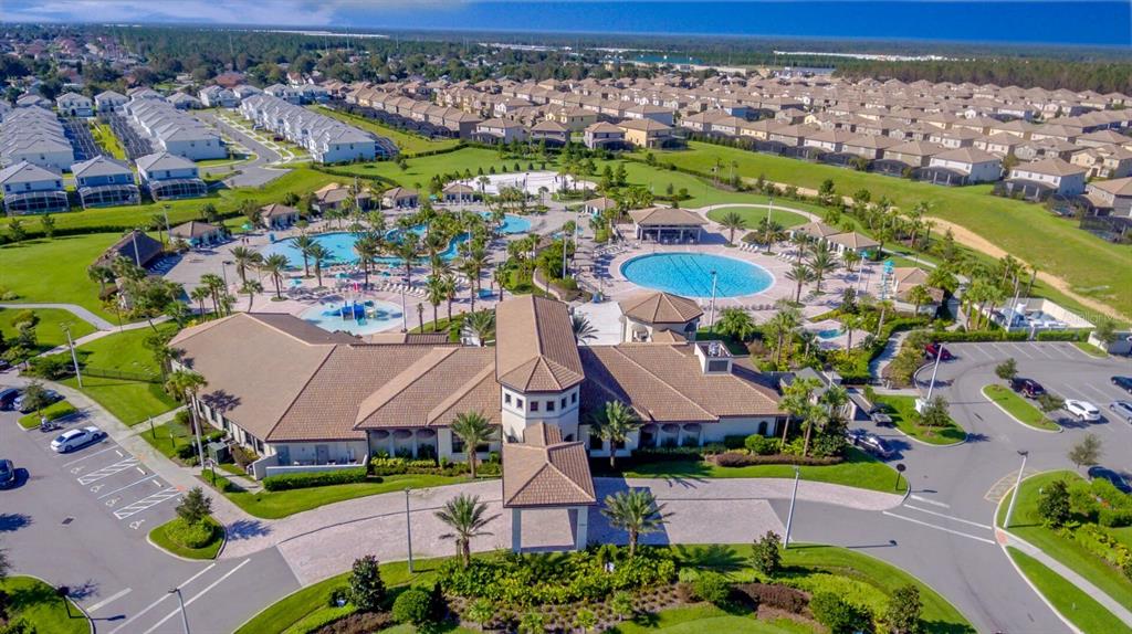 An aerial view shows a community clubhouse with swimming pools, water slides, and parking lots — 8987 BACKSWING WAY, DAVENPORT, FL
