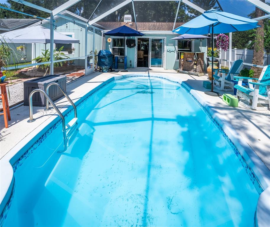 A rectangular swimming pool sits on a patio enclosed by a screened-in lanai — 2941 BAY VIEW DRIVE, SAFETY HARBOR, FL