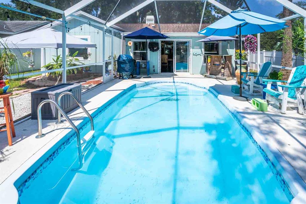 A rectangular swimming pool sits on a patio enclosed by a screened-in lanai — 2941 BAY VIEW DRIVE, SAFETY HARBOR, FL