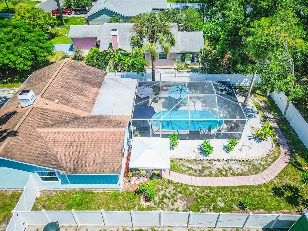 An aerial view shows a house with a screened-in pool and a white fence — 2941 BAY VIEW DRIVE, SAFETY HARBOR, FL