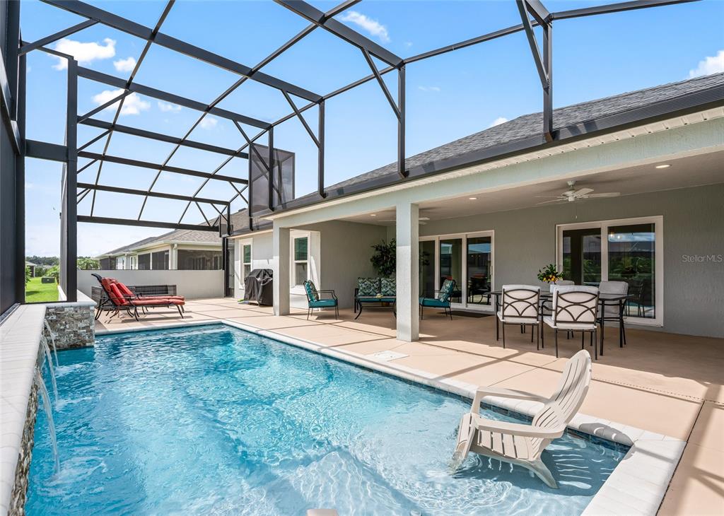 A screened-in patio features a swimming pool with a water feature and outdoor furniture — 3146 JACQUELINE WAY, THE VILLAGES, FL