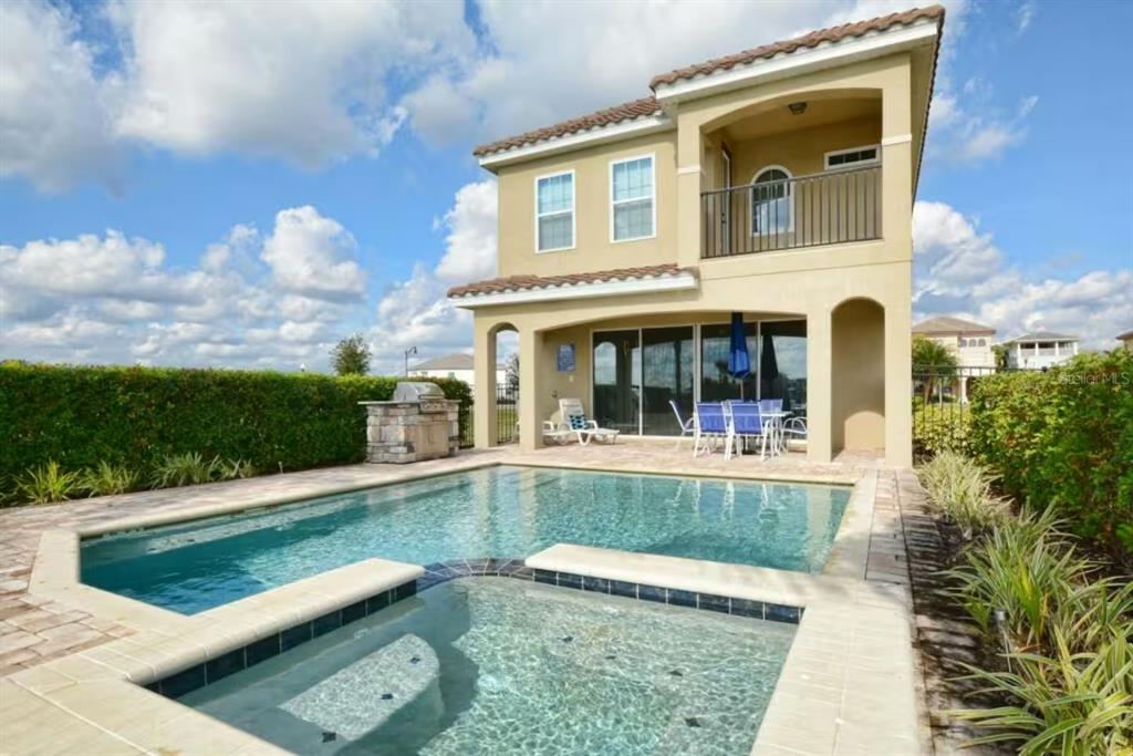 A two-story house with a pool, spa, and covered patio area in the backyard — 7824 LOXAHATCHEE COURT, KISSIMMEE, FL