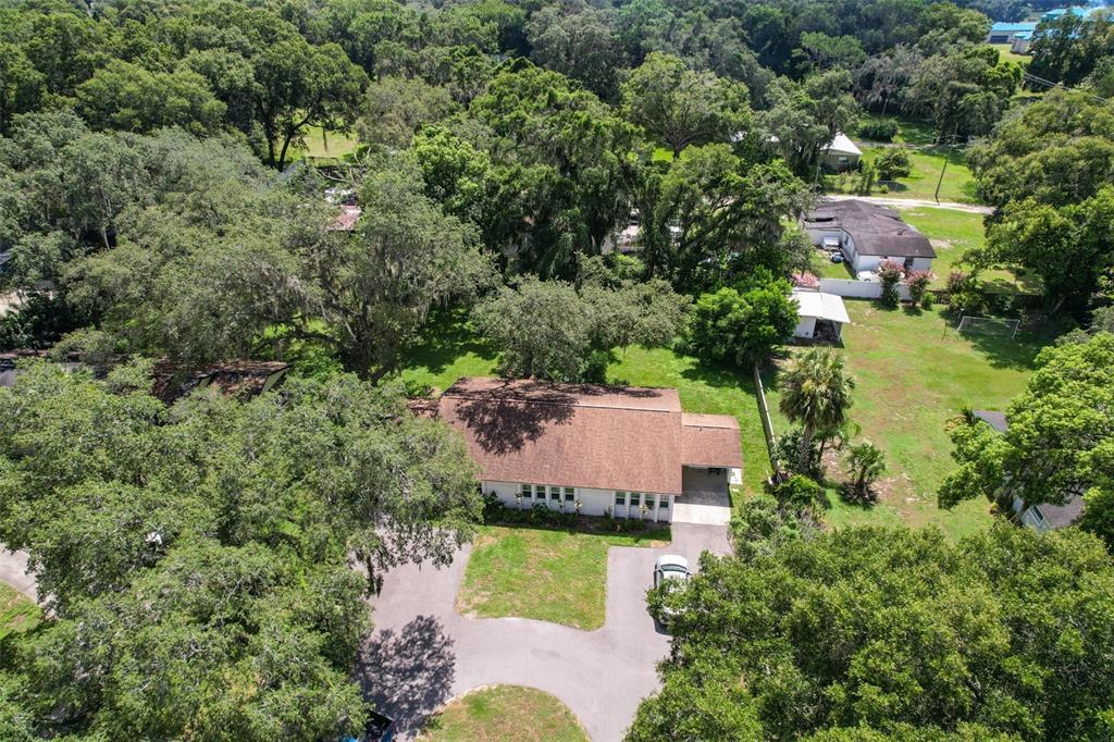 An aerial view shows a single-story house with a brown roof and a circular driveway — 103 N KINGSWAY ROAD, SEFFNER, FL