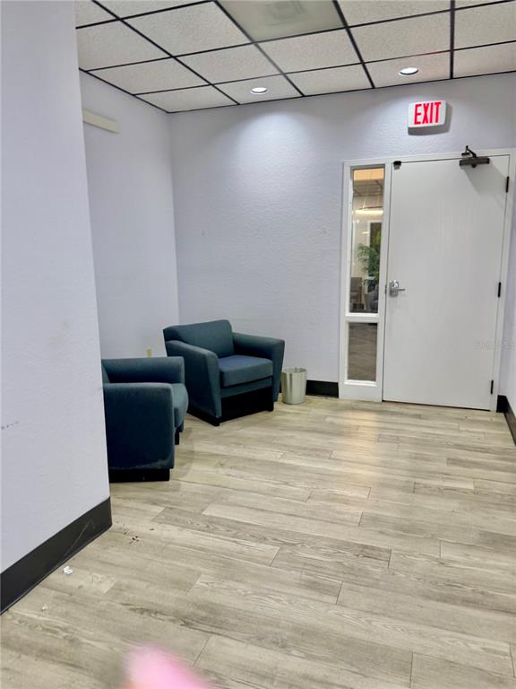 A waiting area features two blue armchairs, light wood-look flooring, and an exit door — 6801 US-27 N UNIT B3, SEBRING, FL