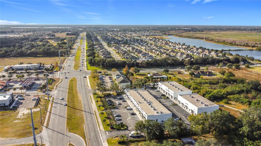 An aerial view shows a commercial plaza, a multi-lane road, and a residential neighborhood — 1370 S NARCOOSSEE ROAD, ST CLOUD, FL