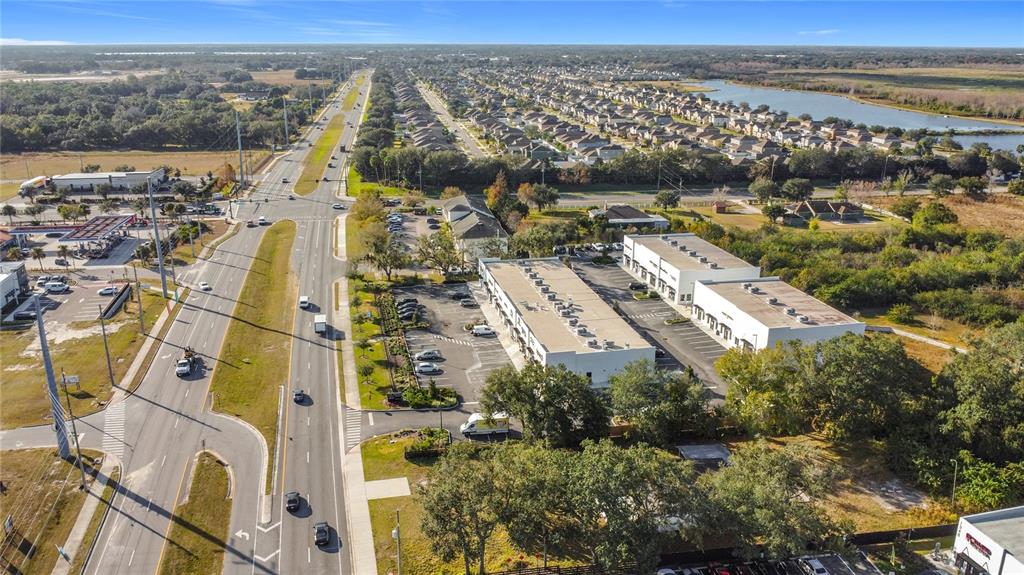 An aerial view shows a commercial plaza with two buildings next to a multi-lane road — 1370 S NARCOOSSEE ROAD, ST CLOUD, FL