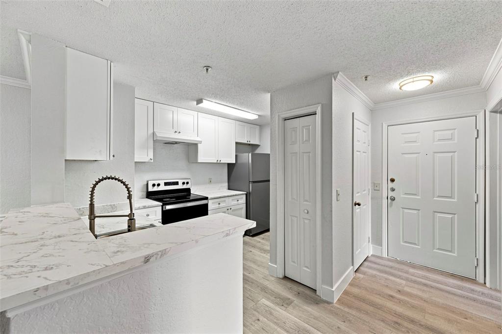 A composite image shows a swimming pool, an apartment building exterior, a kitchen, and a living room — 18001 RICHMOND PLACE DRIVE UNIT 136, TAMPA, FL
