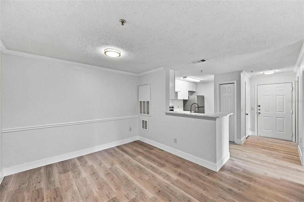 A kitchen sink with a high-arc faucet overlooks a living area with a balcony — 18001 RICHMOND PLACE DRIVE UNIT 136, TAMPA, FL