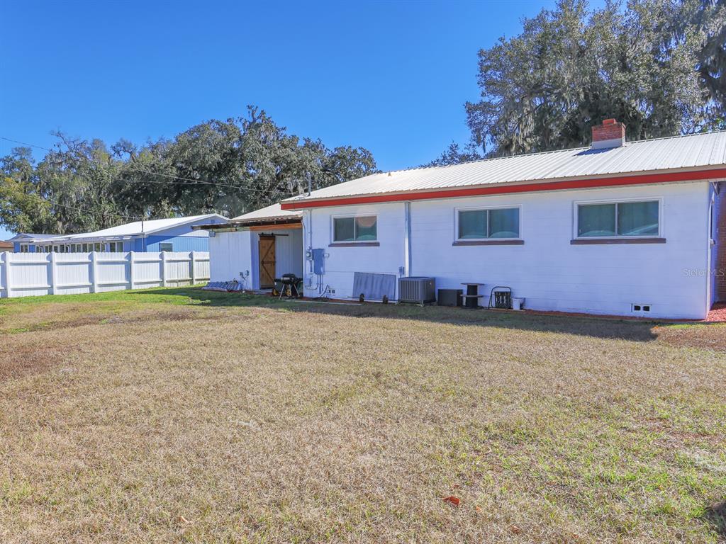 A white house with a metal roof and a large backyard with a white fence — 2140 E MAIN STREET, BARTOW, FL