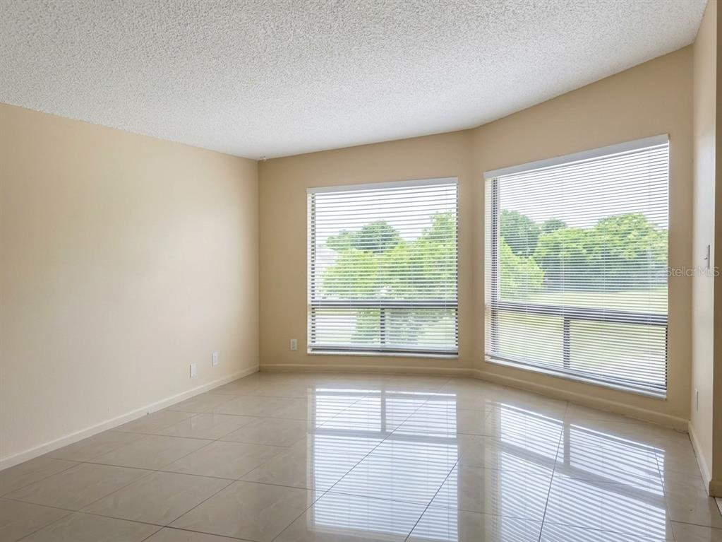 A bedroom features a wooden dresser with a mirror, a bed, and teal curtains — 2512 LEMON TREE LANE UNIT 3C, ORLANDO, FL