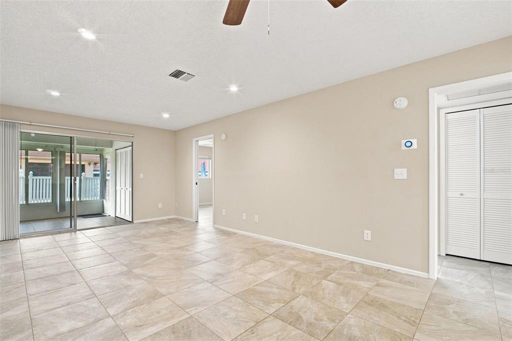 A living room with beige walls, tile flooring, recessed lighting, and a sliding glass door — 2460 NORTHSIDE DRIVE UNIT 1202, CLEARWATER, FL