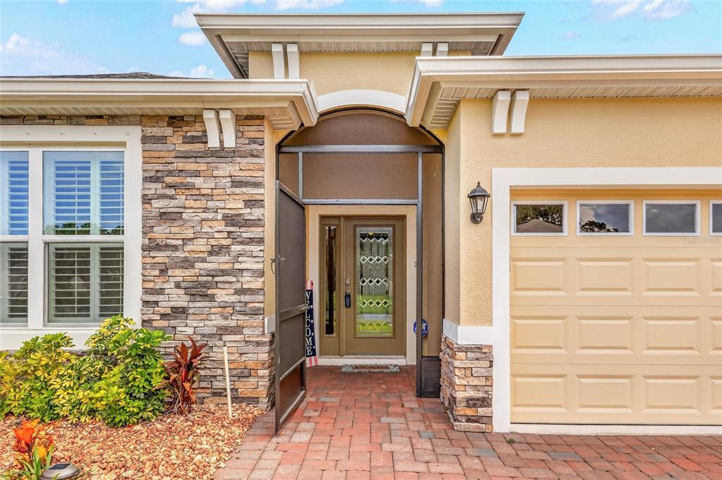 The exterior of a house features a stone facade, a tan garage, and a front entrance — 6691 CAMEO DRIVE, GRANT, FL
