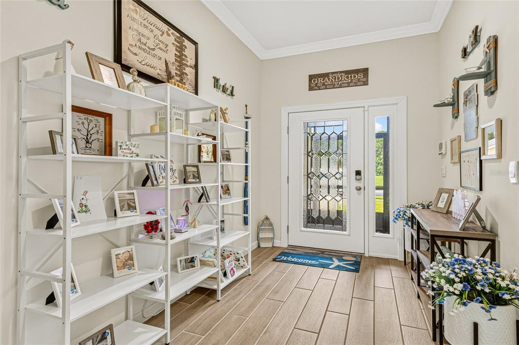An entryway with a white shelving unit, a wooden console table, and a glass-paneled door — 6691 CAMEO DRIVE, GRANT, FL