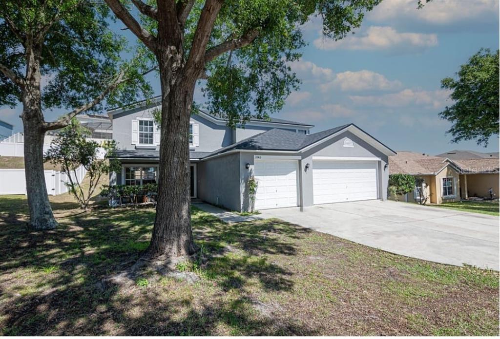 A two-story gray house with a two-car garage and large trees in the front yard — 1846 WAKE FOREST AVENUE, CLERMONT, FL