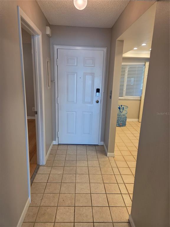 A living room with hardwood floors, a ceiling fan, and an open kitchen pass-through — 650 ISLAND WAY UNIT 202, CLEARWATER BEACH, FL