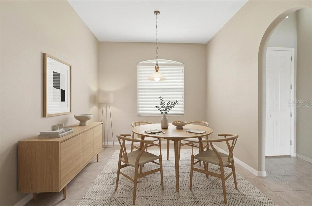 This dining room features a round wooden table, four chairs, a sideboard, and a rug — 30718 PUMPKIN RIDGE DRIVE, WESLEY CHAPEL, FL