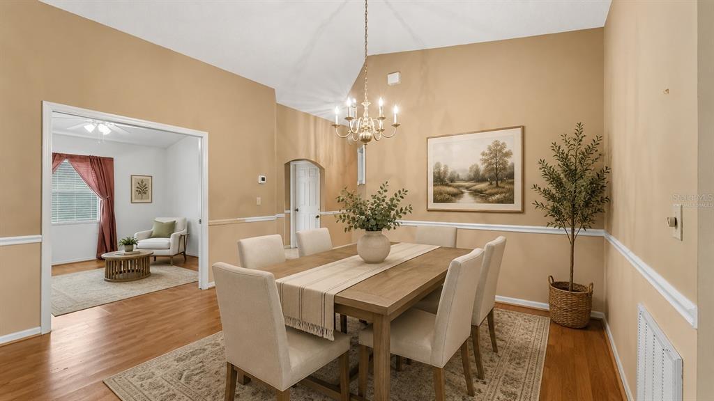 A living room with beige walls, a chandelier, wood flooring, and an adjacent home office — 2191 SILVER RE DRIVE, LAKELAND, FL