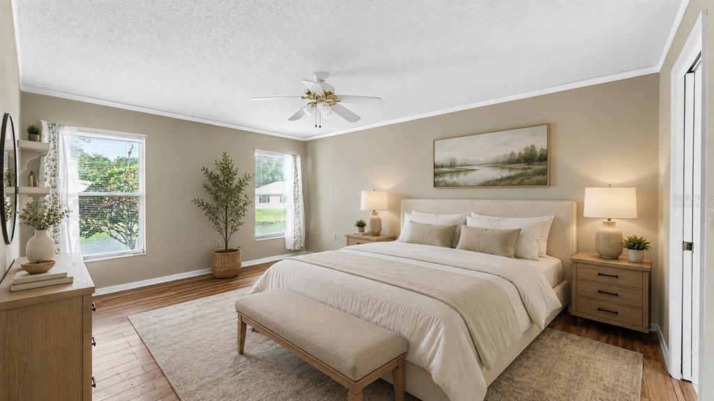 A living room with wood-look flooring, a chandelier, a ceiling fan, and a glass door — 2191 SILVER RE DRIVE, LAKELAND, FL