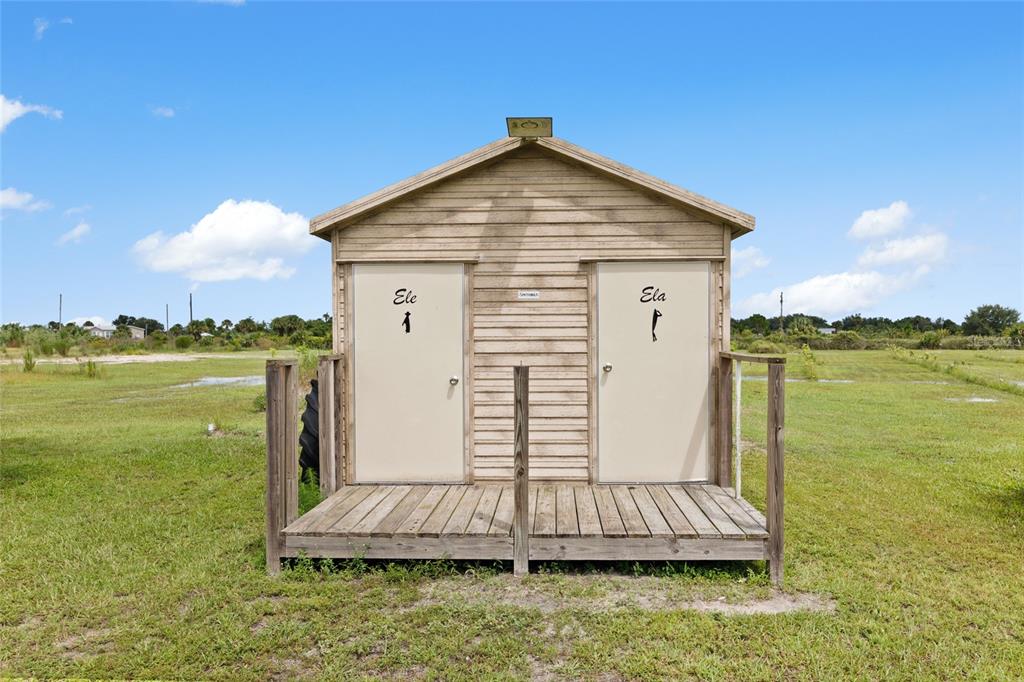 A small, wooden shed with two separate doors stands on a raised wooden deck — 20914 NW 280TH STREET, OKEECHOBEE, FL