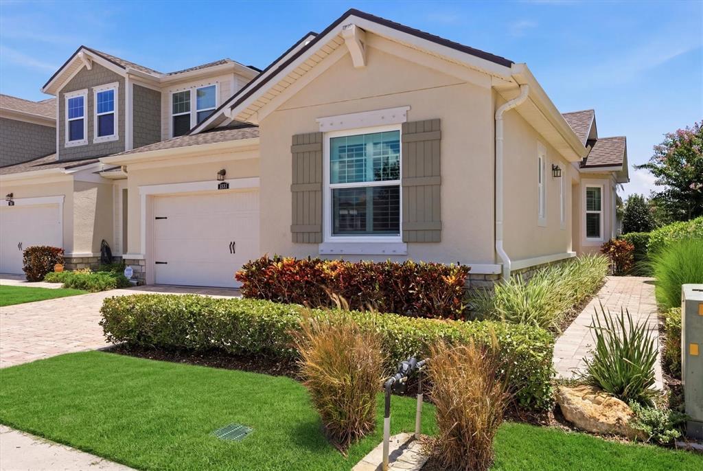 A single-story suburban house with a beige stucco exterior, a garage, and landscaped front yard — 3681 DIVOT LANE, SARASOTA, FL