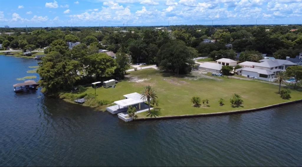 An aerial view shows a grassy waterfront lot with a boat dock and storage trailers — 2403 EUSTON ROAD, WINTER PARK, FL