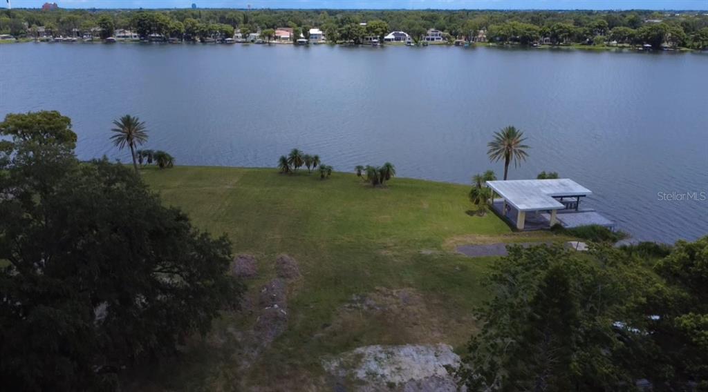 An aerial view shows a grassy waterfront lot with a boat dock and palm trees — 2403 EUSTON ROAD, WINTER PARK, FL