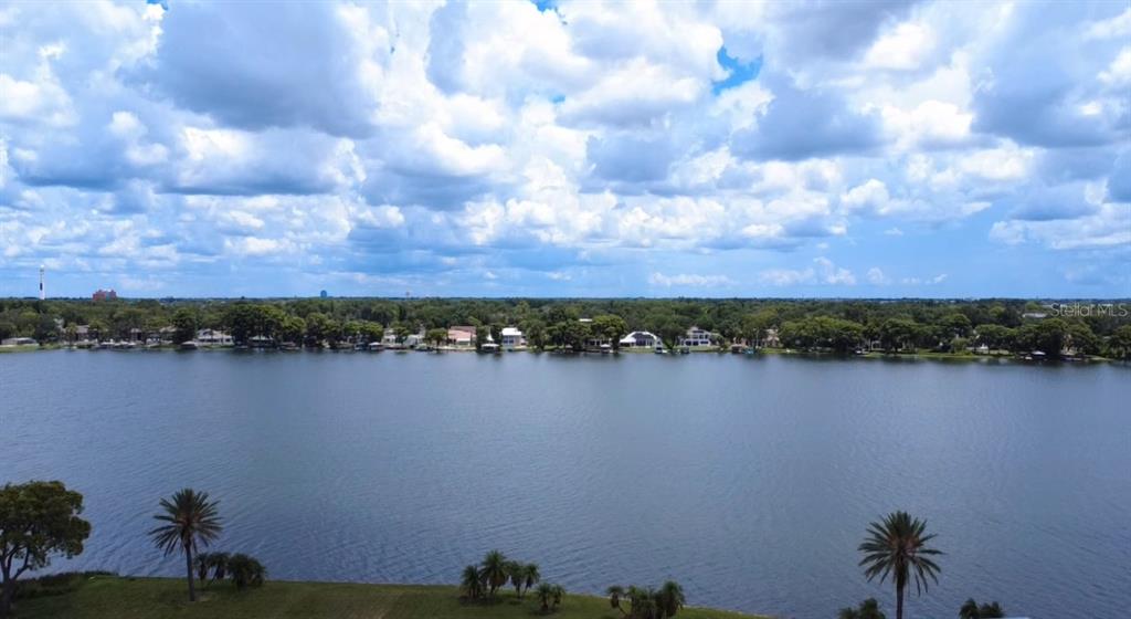 An aerial view shows a large lake bordered by trees and residential houses under a cloudy sky — 2403 EUSTON ROAD, WINTER PARK, FL