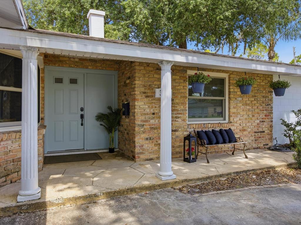 A brick house exterior features a light blue front door, white columns, and a stone porch — 333 CORNWALL ROAD, WINTER PARK, FL